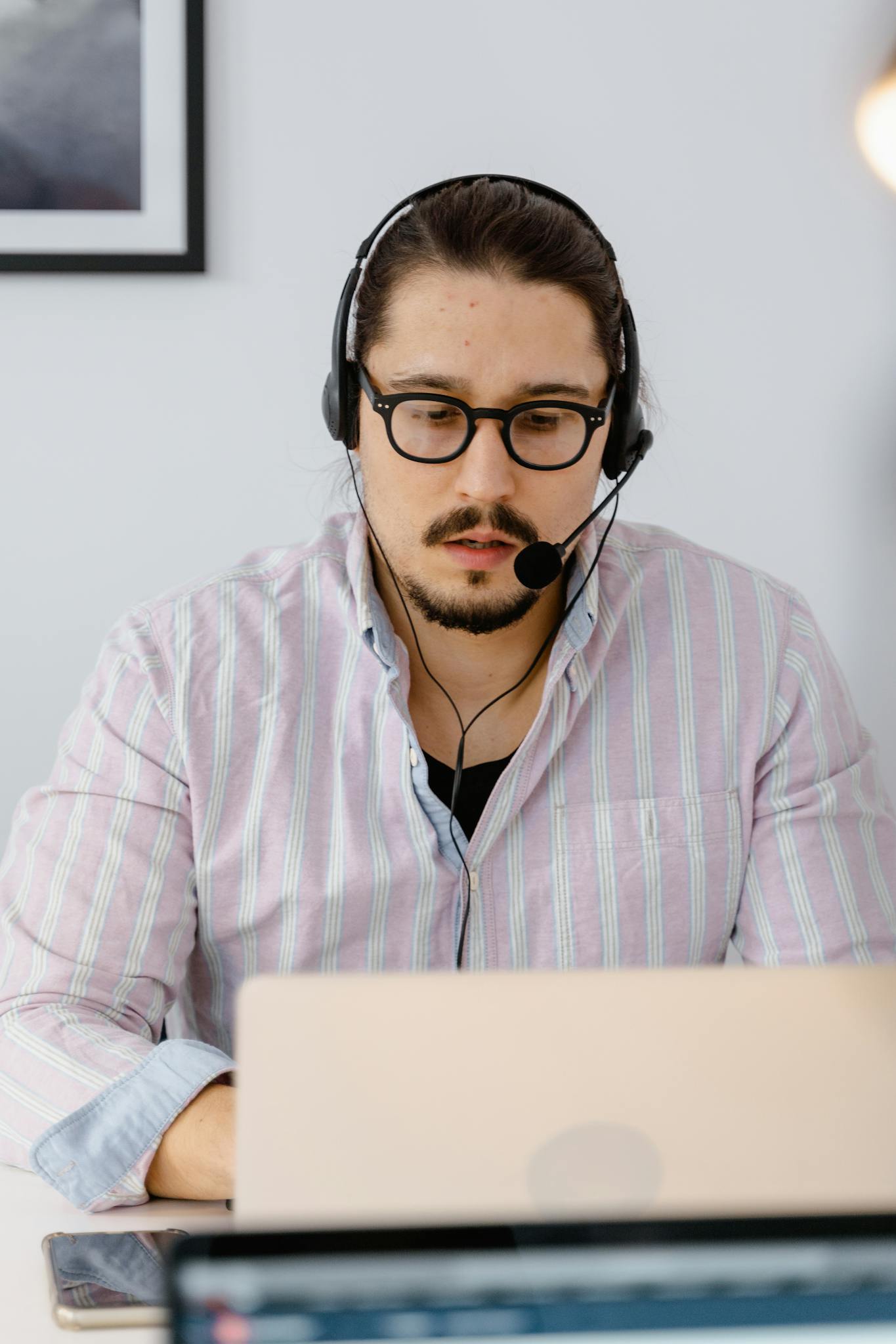 Professional customer support agent working remotely with headset and laptop, focusing on providing excellent service.